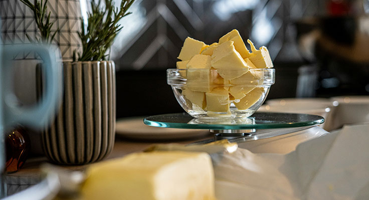 Butter slices in glass bowl on kitchen counter.