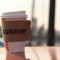 Disposable coffee cup on car roof at sunset