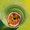 Passion fruit in glass on green background.