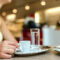 Person enjoying coffee and sundae at cafe.