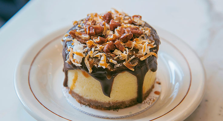 Decadent chocolate-topped cheesecake with pecans and coconut.