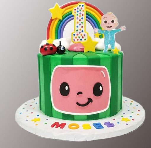 Colorful themed birthday cake with name Moses.