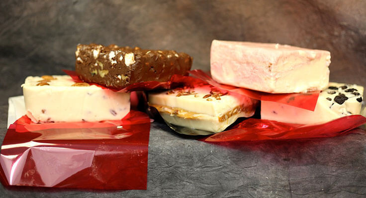 Assorted gourmet chocolate bars on red foil.