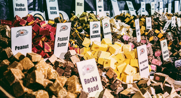 Assorted fudge flavors at a market display.