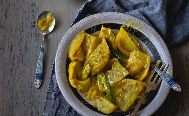Homemade ravioli in a bowl with fork and spoon.