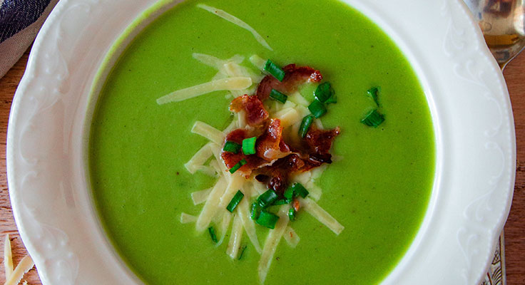 Green pea soup with bacon and cheese garnish.