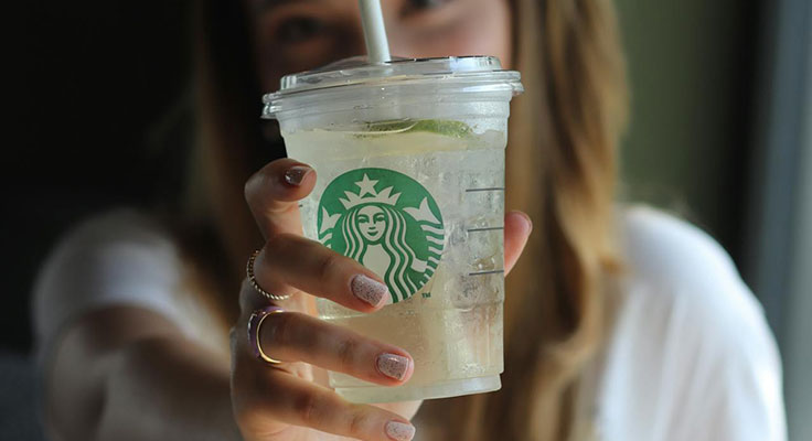 Woman holding iced Starbucks drink.