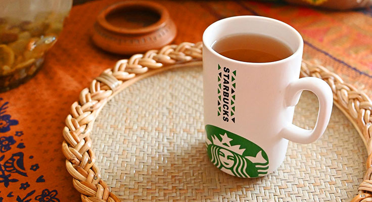 Starbucks mug on woven table mat.