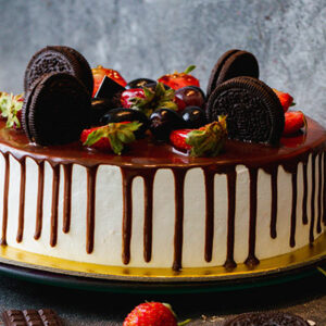 Chocolate drip cake with strawberries and cookies.