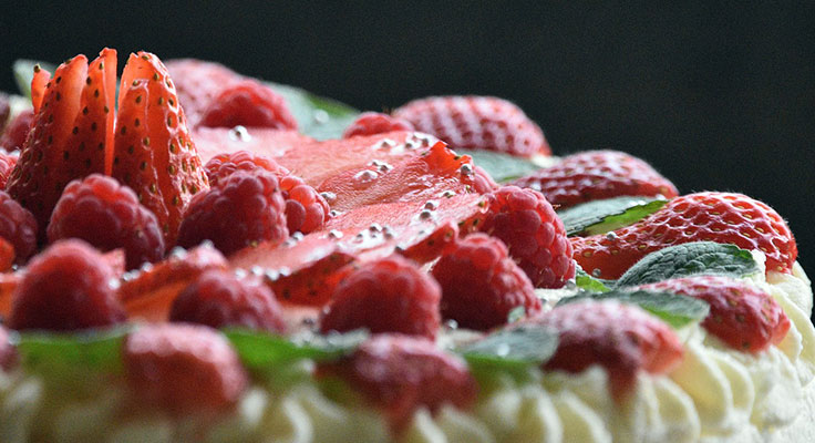 Fresh strawberry raspberry cake with water droplets.