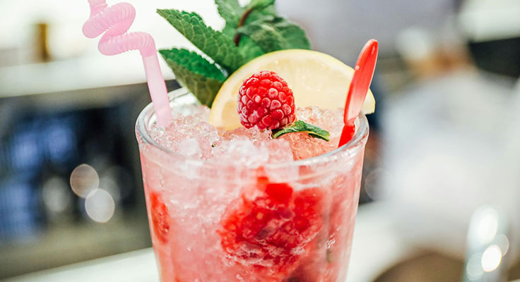 Refreshing raspberry lemonade cocktail with mint garnish.