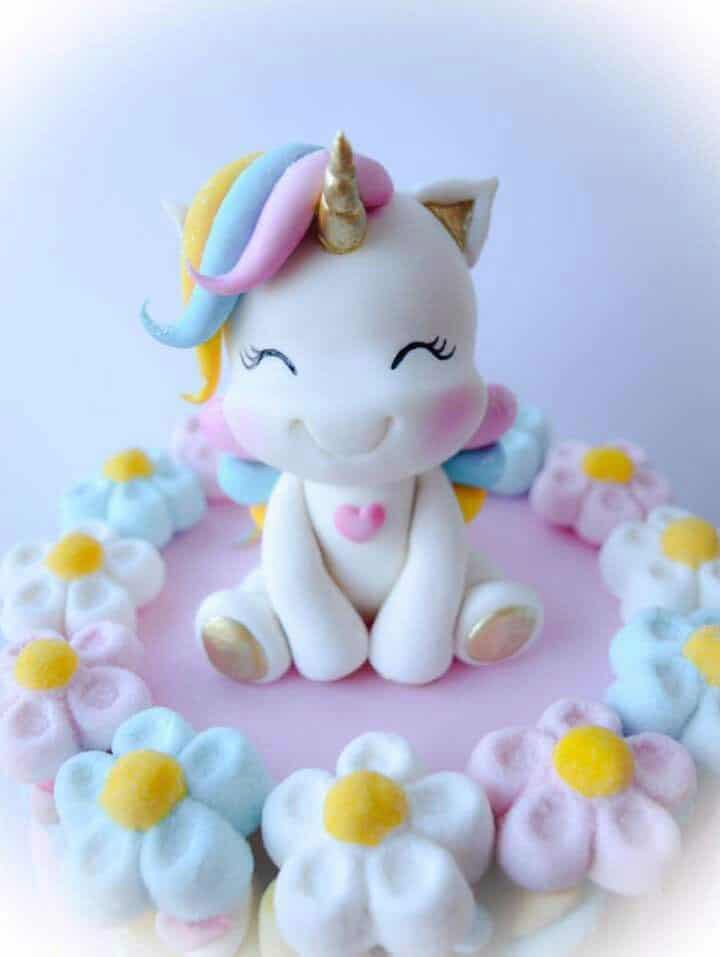 Colorful unicorn figurine surrounded by pastel flowers.
