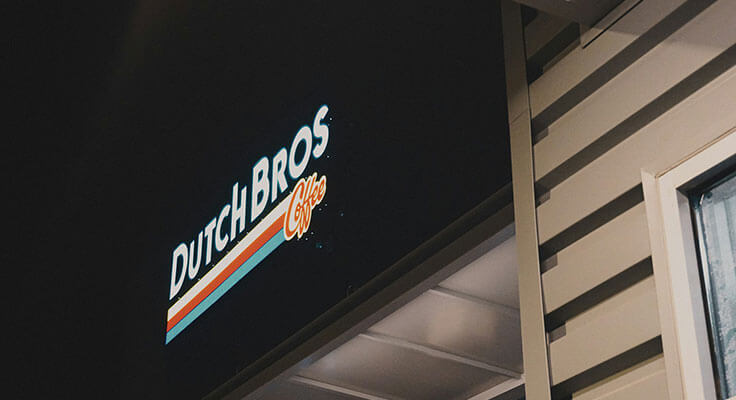 Dutch Bros Coffee illuminated sign at night.