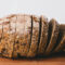 Sliced whole grain bread on wooden board.