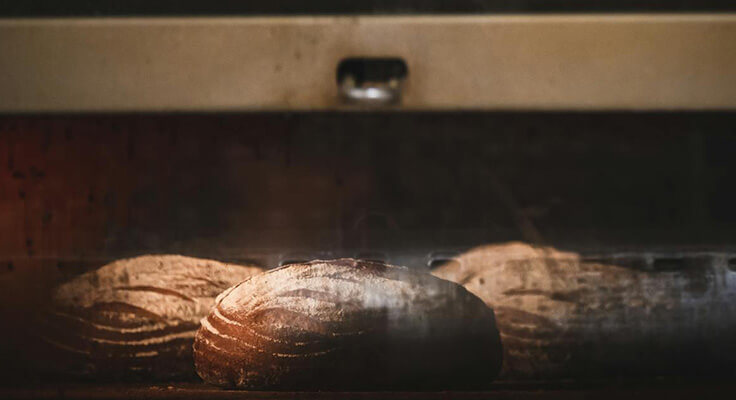 Artisan bread loaves baking in oven.