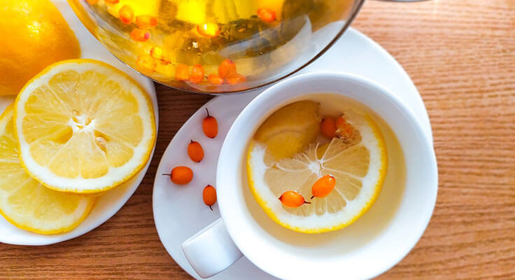 Lemon sea buckthorn tea in cup and teapot.
