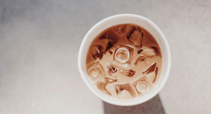 Iced coffee in cup, top view.