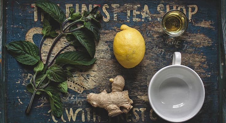 Fresh tea ingredients on vintage wooden table.