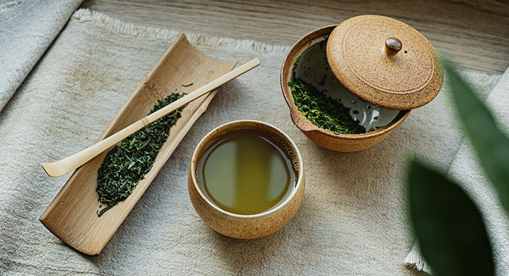 Traditional green tea set on wooden table.