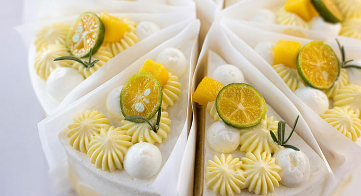Lemon cake slices with decorative icing and fruit toppings.