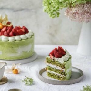 Green tea cake with strawberries on a white background