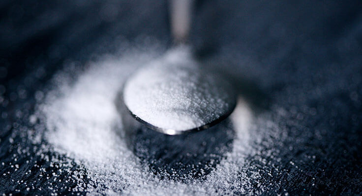 Spoonful of sugar on dark background