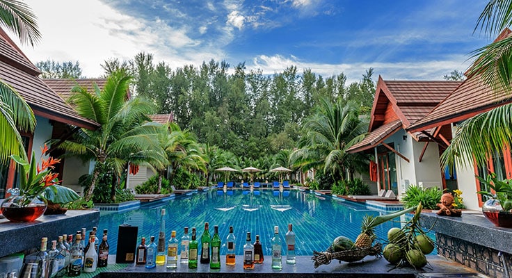 Tropical resort pool with bar and palm trees