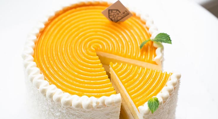 Mango-flavored cheesecake with one slice removed.