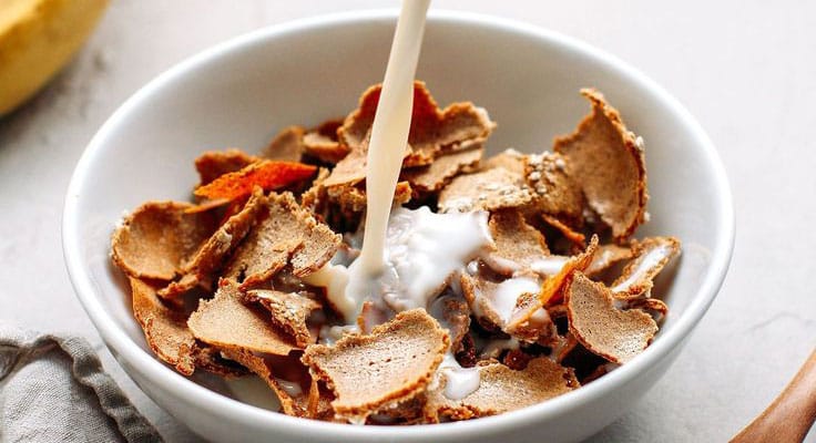 Bowl of cereal with milk pouring in.
