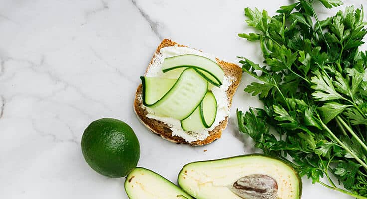 Toast with cream cheese, cucumber, avocado, lime, parsley.