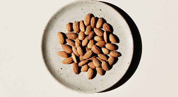 Almonds on a ceramic plate, top view
