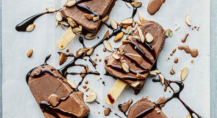 Chocolate popsicles with almonds and chocolate drizzle.