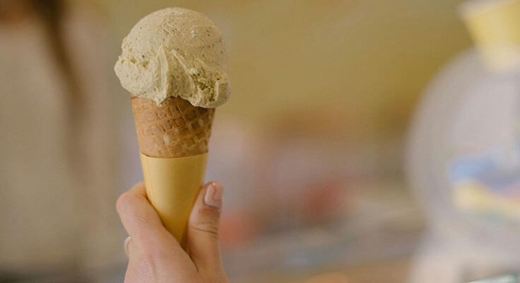 Hand holding ice cream cone.
