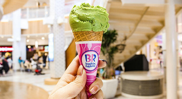 Baskin Robbins green ice cream cone in hand.