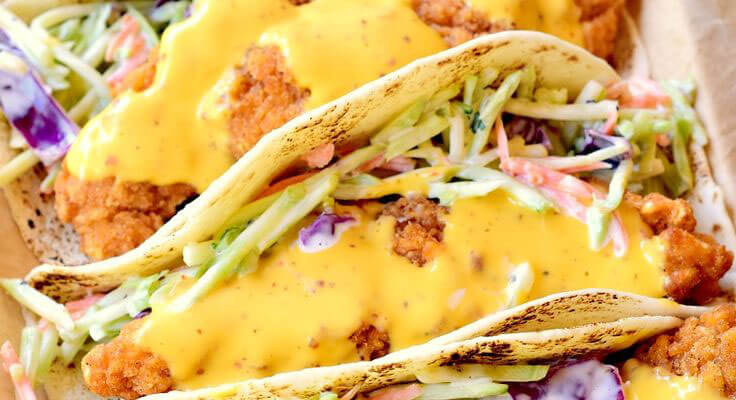 Chicken tacos with cheese sauce.