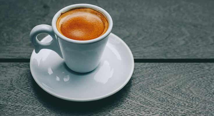 Espresso coffee in white cup on table