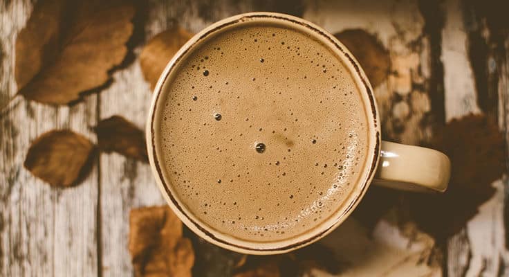 Cup of coffee with autumn leaves