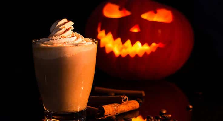 Pumpkin spice latte with carved pumpkin