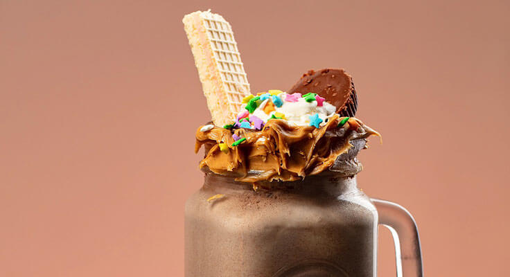 Decadent chocolate milkshake with whipped cream and toppings.