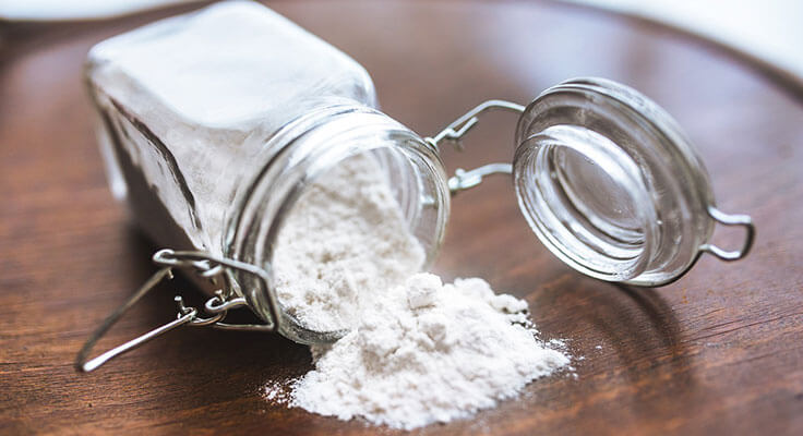Spilled jar of white flour on table