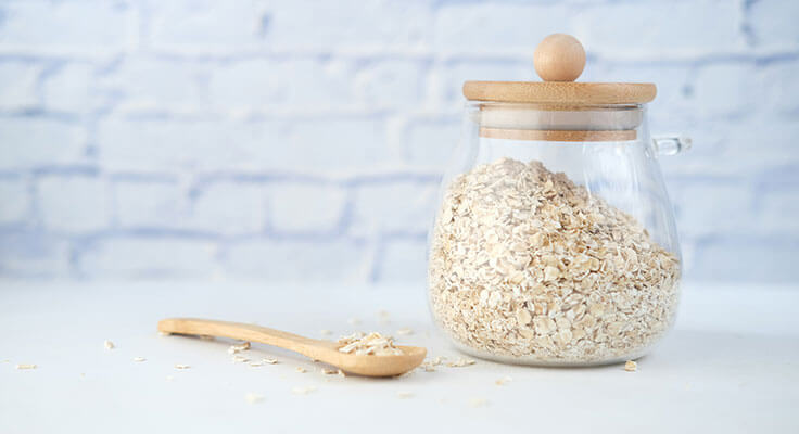 Jar of oats with wooden spoon.