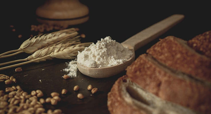 Wheat, flour, and bread on a dark background