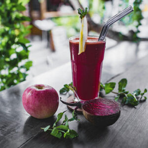 Beet juice with apple and beet on table