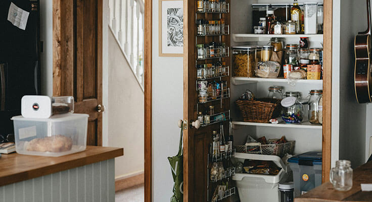Organized kitchen pantry with various food items.