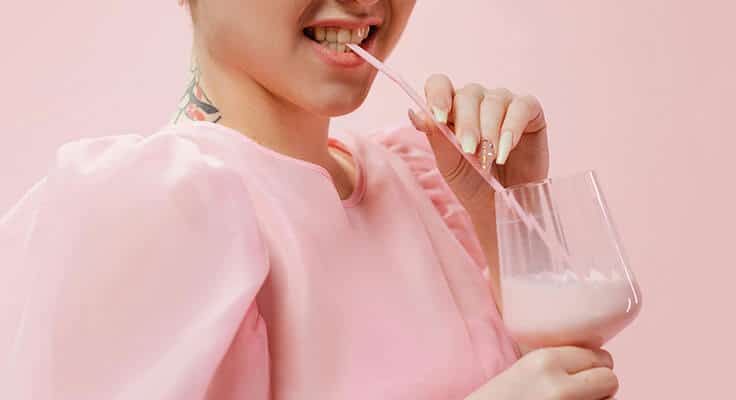 drinking pink smoothie with a straw
