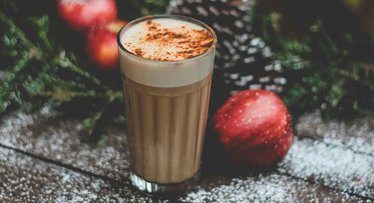 Pumpkin spice latte with apples and pinecones.