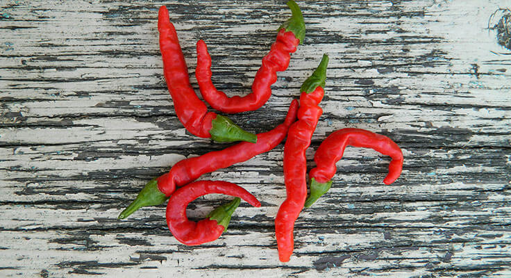 Red chili peppers on wooden surface