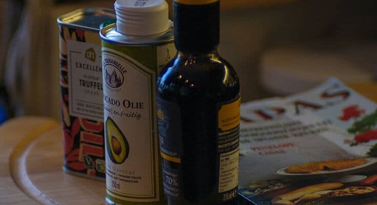 Truffle oil, avocado oil, and magazine on table