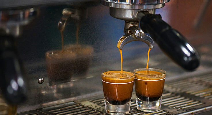 Fresh espresso being brewed into shot glasses