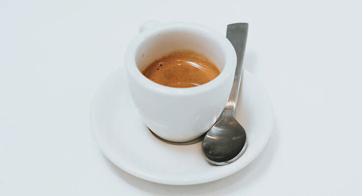 Espresso in a white cup with spoon.